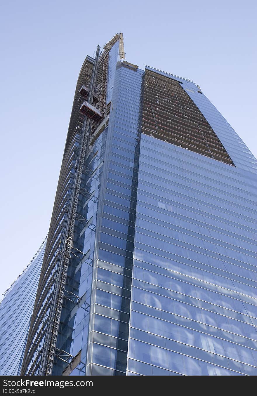 A new modern blue glass tower under construction. A new modern blue glass tower under construction