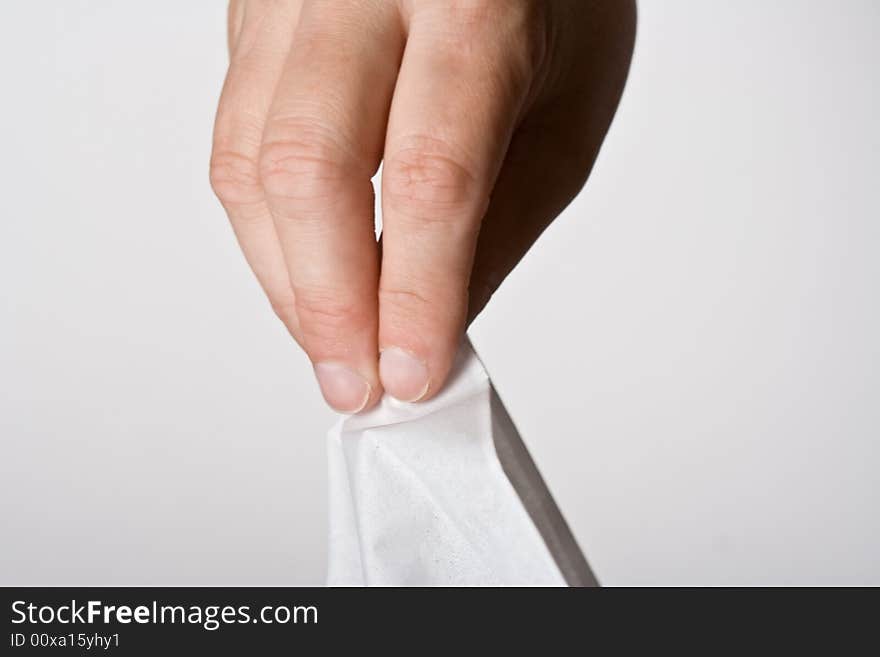 Womens hand grabbing a tissue out of the box on a off white background. Womens hand grabbing a tissue out of the box on a off white background