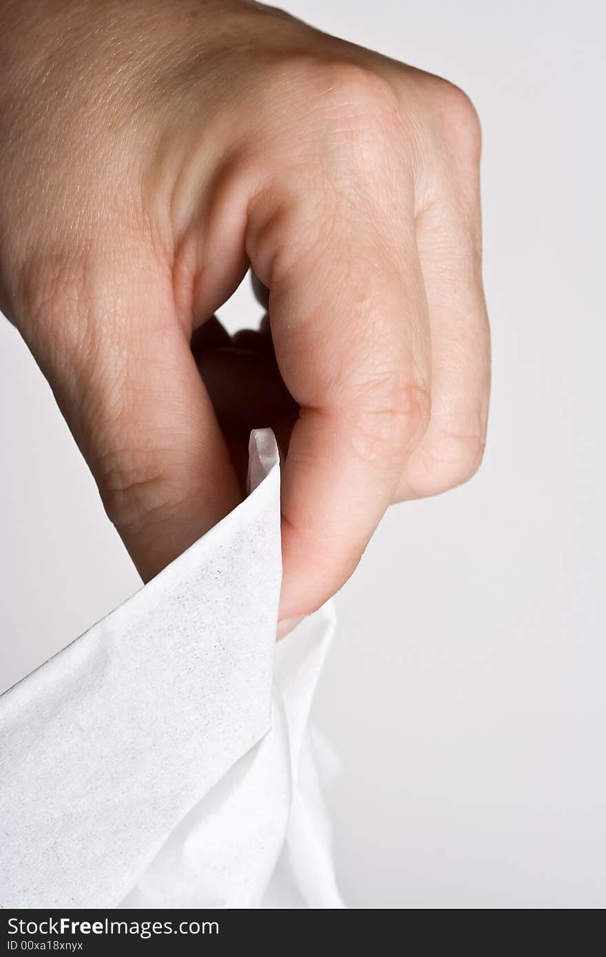 Womens hand grabbing a tissue out of the box on a off white background. Womens hand grabbing a tissue out of the box on a off white background