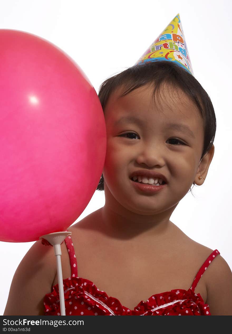 Toddler girl with party hat and balloon