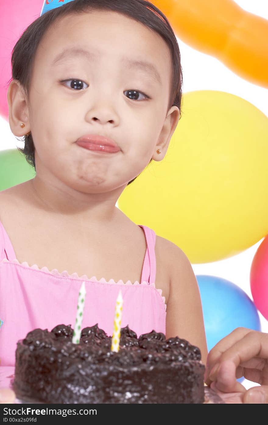 Birthday girl holding cake with the colorful balloons