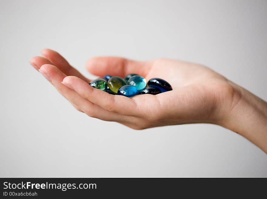 The hand holds round multi-coloured slices of glass. Close-up. Shallow depth of field. The hand holds round multi-coloured slices of glass. Close-up. Shallow depth of field.