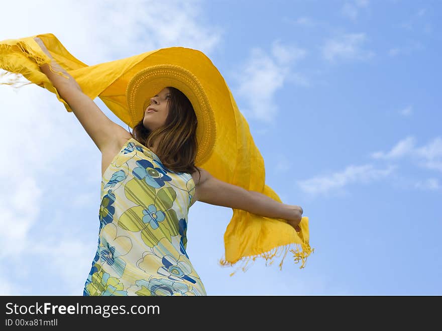 Young Woman Holding Orange Wrap Against Blue Sky