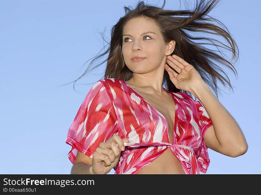 Attractive brunette woman on sky background