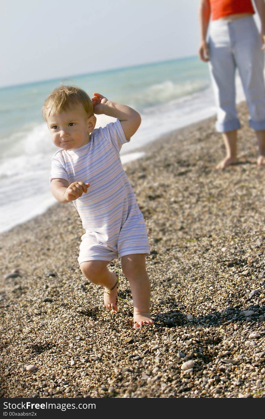 Baby going away from mother on beach. Baby going away from mother on beach