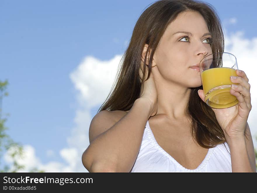 Beautiful girl drinking morning orange on balcony