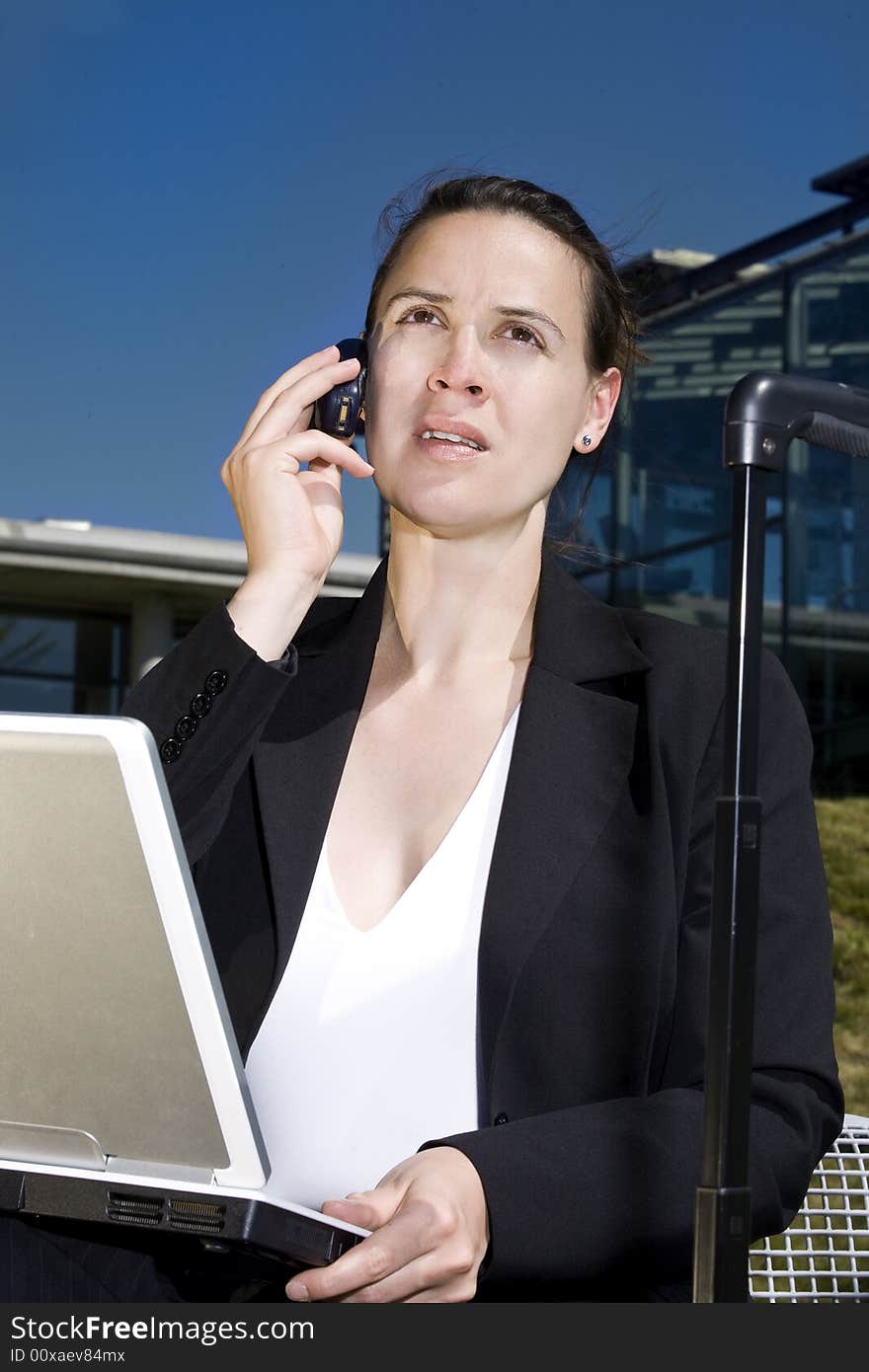 A businesswoman accessing on the road in an outdoor setting. A businesswoman accessing on the road in an outdoor setting