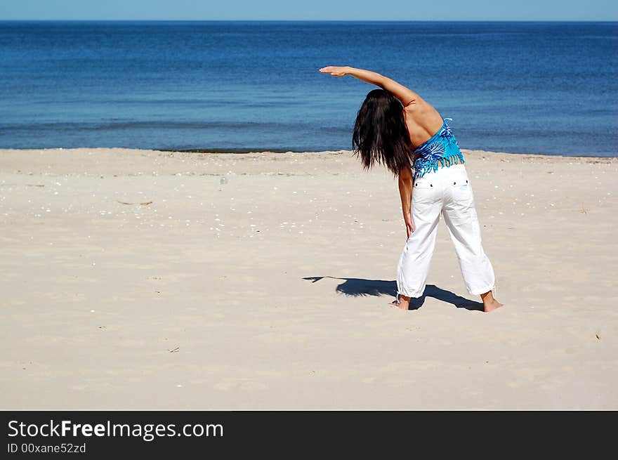 Attractive woman doing exercise on the beach