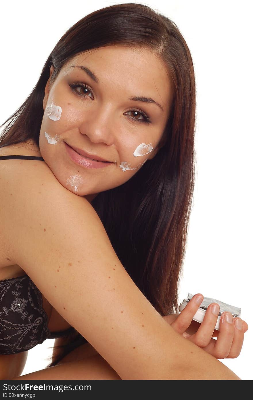 Attractive brunette woman applying cream on white background