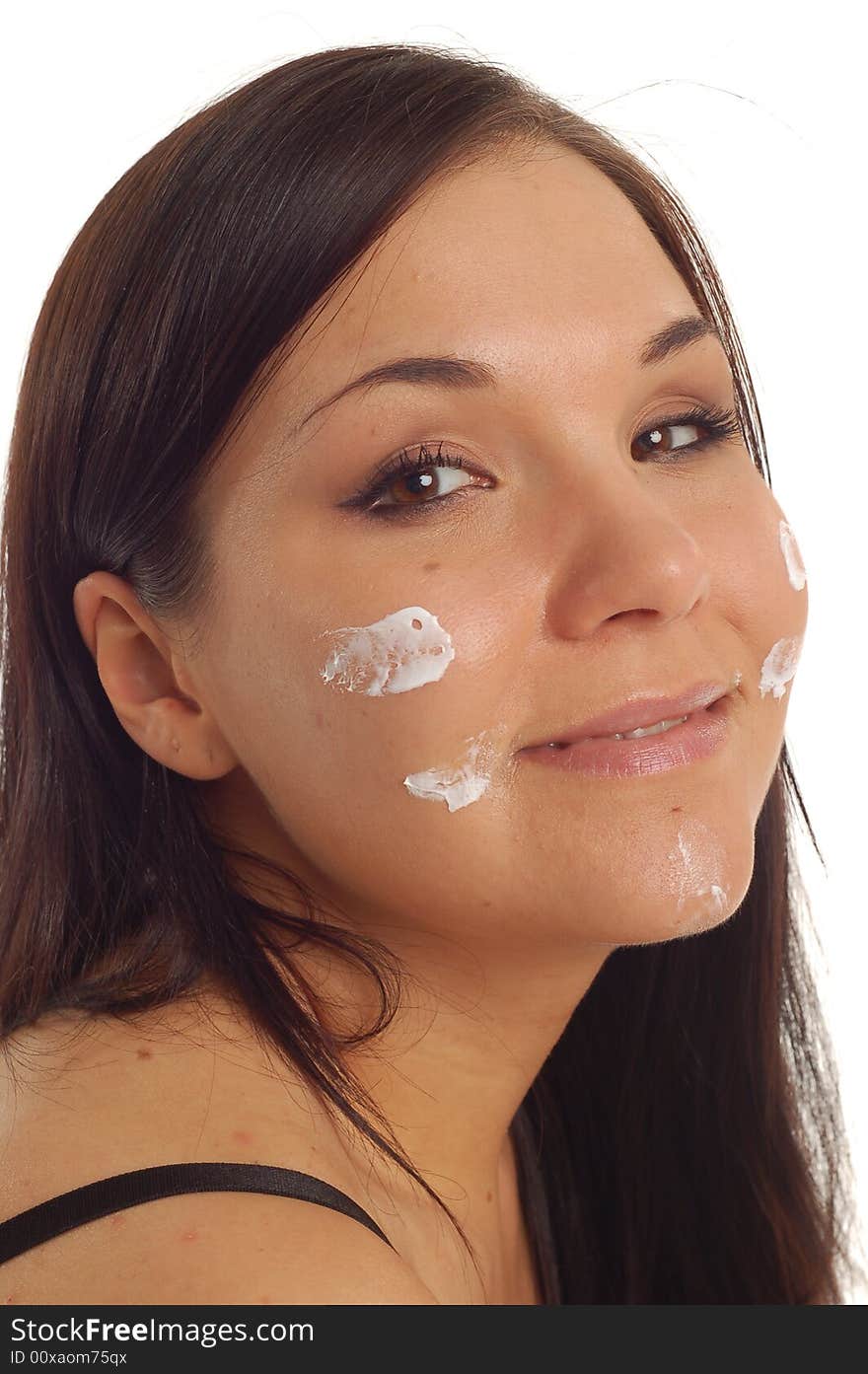 Attractive brunette woman applying cream on white background