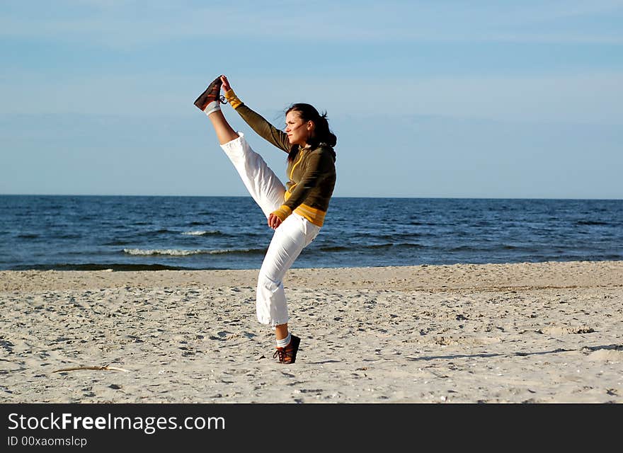 Attractive woman doing exercise on the beach