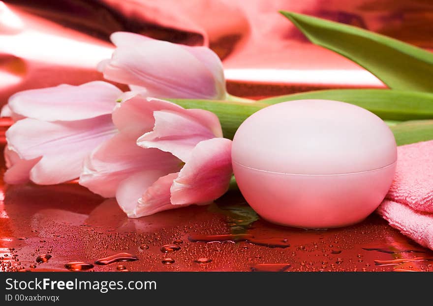 Cream, towel with flowers on red background