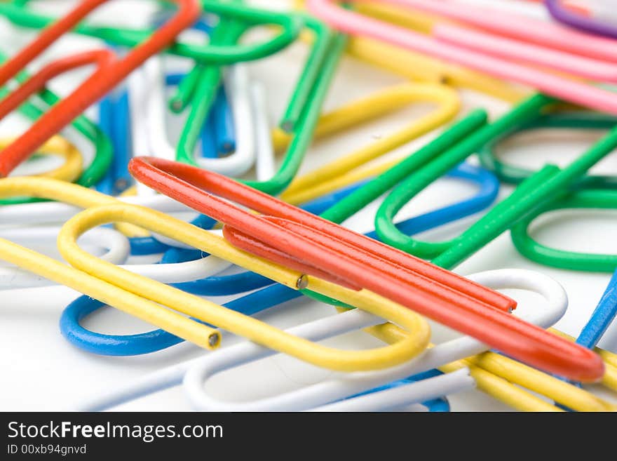 Colorful paper clips on a white background. Close up. Selective focus.