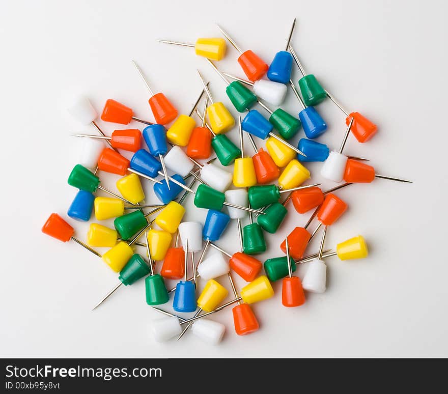 Colored pins on a white background. Close up. Selective focus. Colored pins on a white background. Close up. Selective focus.