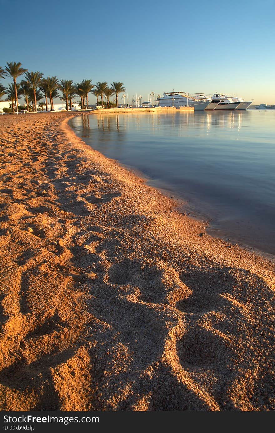 Beach line, bosts and palms on horizon. Beach line, bosts and palms on horizon