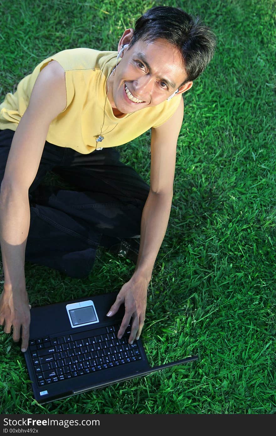 Man, music and laptop on green grass outdoor