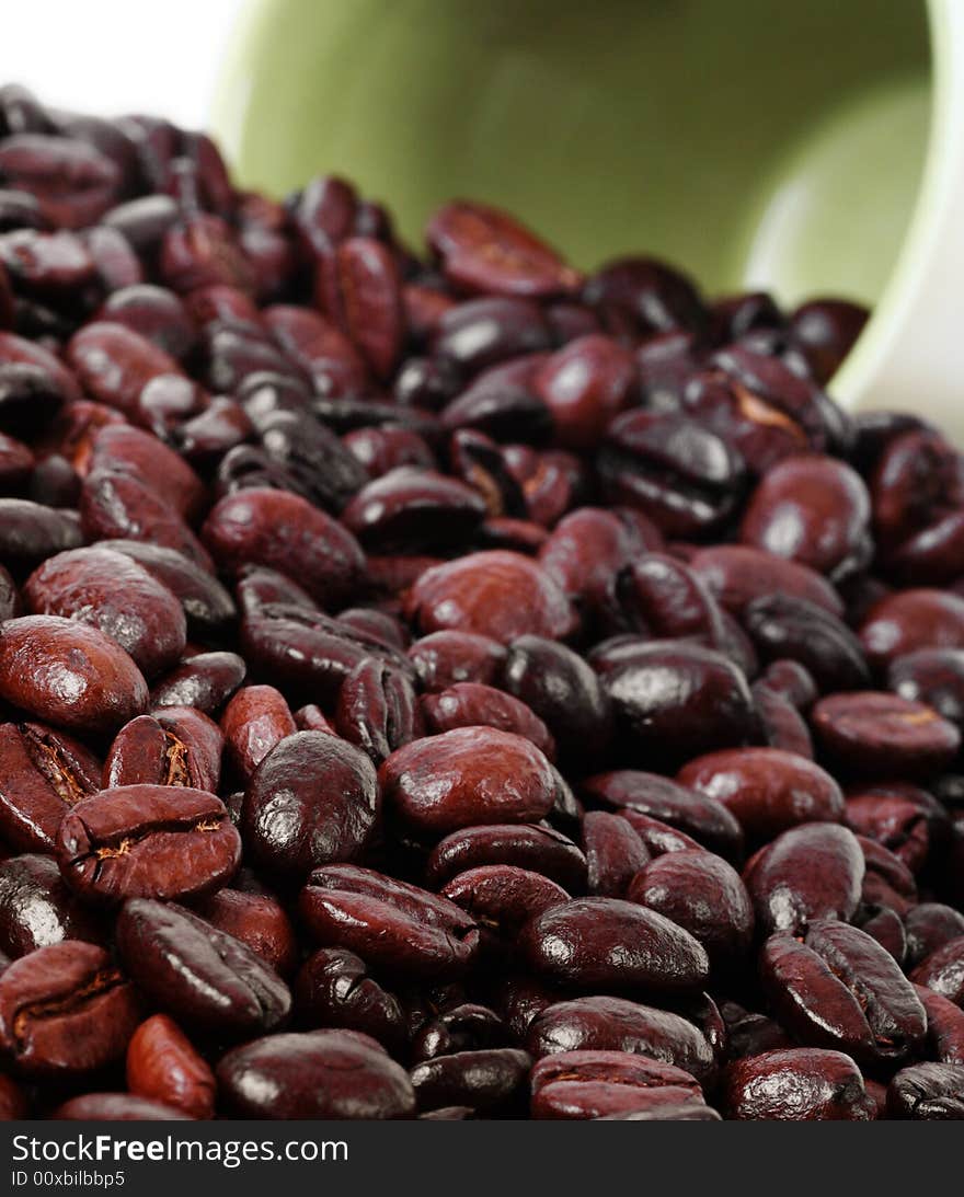 Close up of the coffee beans with mug in the background