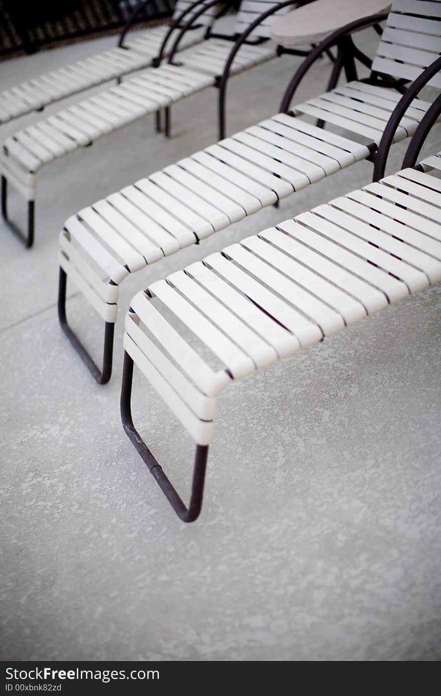 A group of pool chairs outside next to the pool in the summer