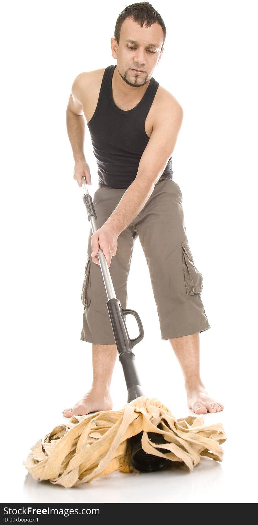 Young happy man standing with hand on hip and mop in second hand and looking at camera. Whole body. Front view. White background. Young happy man standing with hand on hip and mop in second hand and looking at camera. Whole body. Front view. White background.