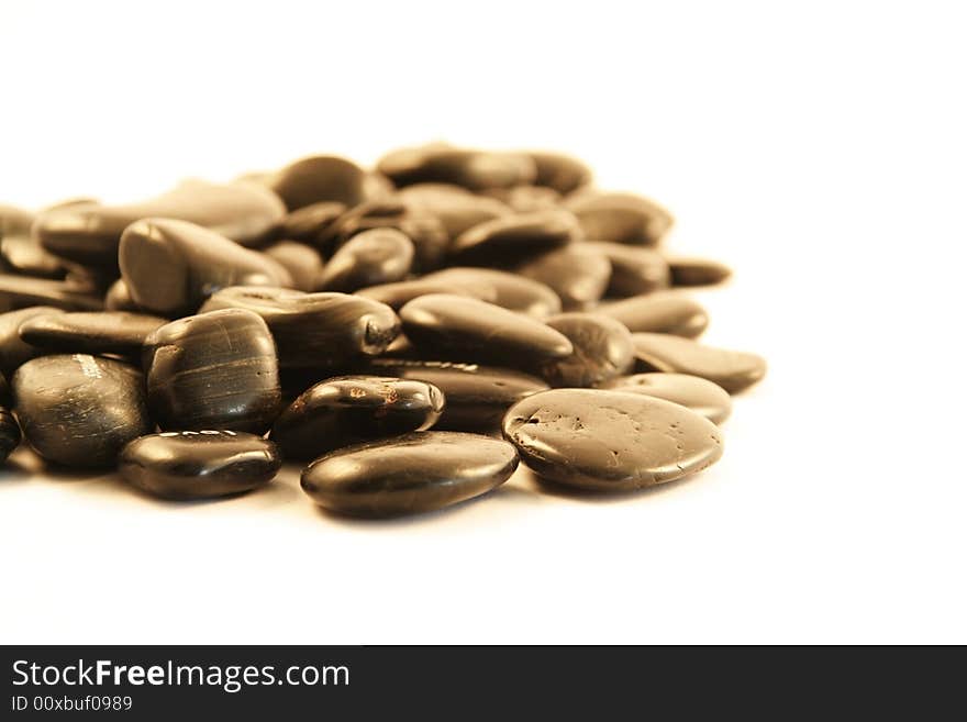 Black pebbles on a white background (shallow DOF)