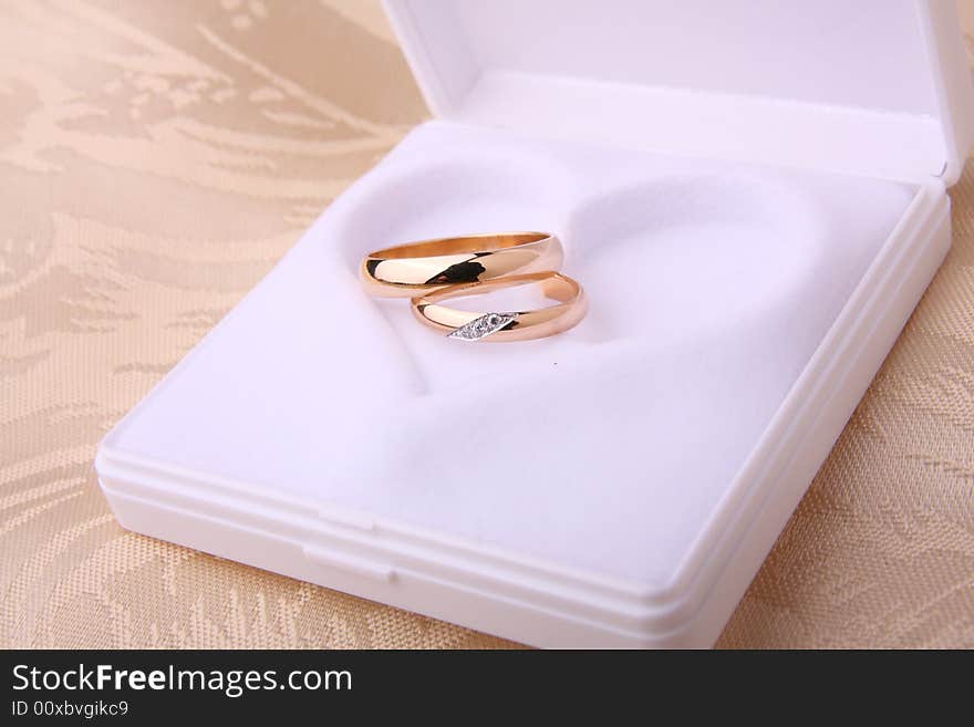 Wedding rings in jewelry box with heart shape