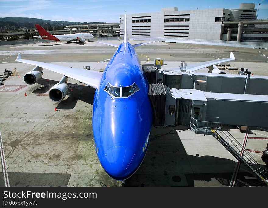 Blue airplane being refuelled on a runway. Blue airplane being refuelled on a runway