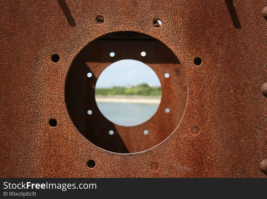 Looking through a rusty porthole with the center with a shallow DOF