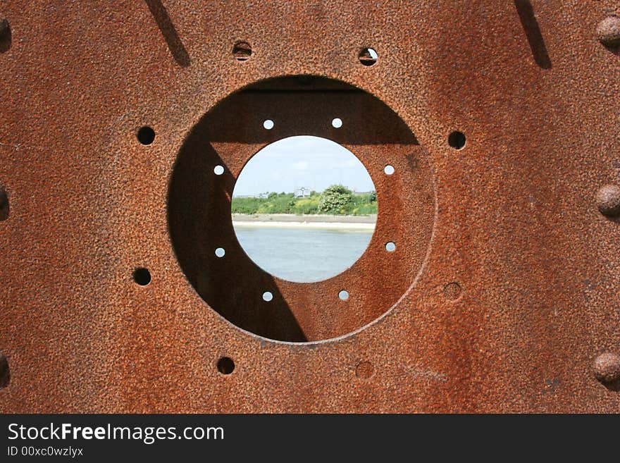 Looking through a rusty porthole with the center with a Sharp DOF. Looking through a rusty porthole with the center with a Sharp DOF