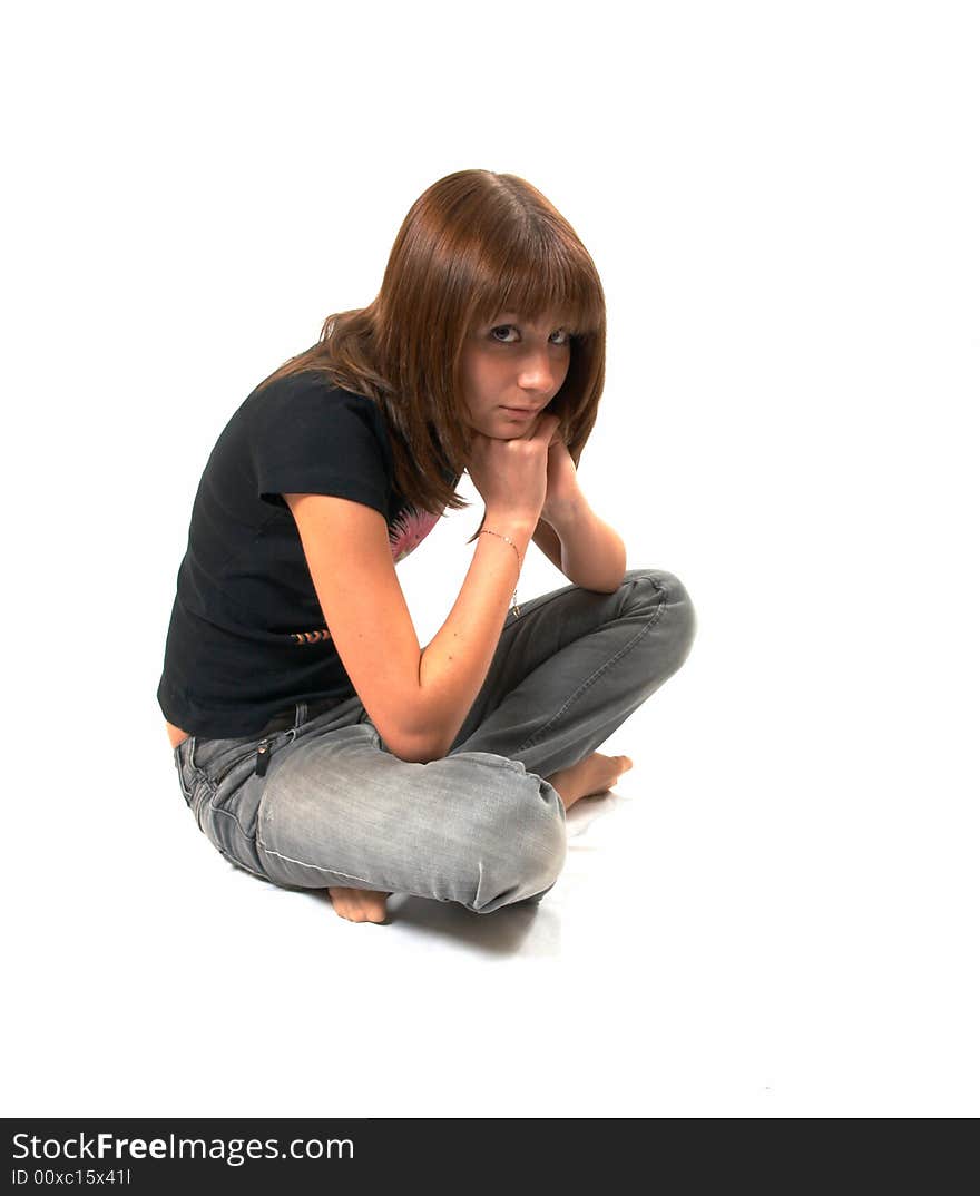 Girl in a black vest sits on a floor