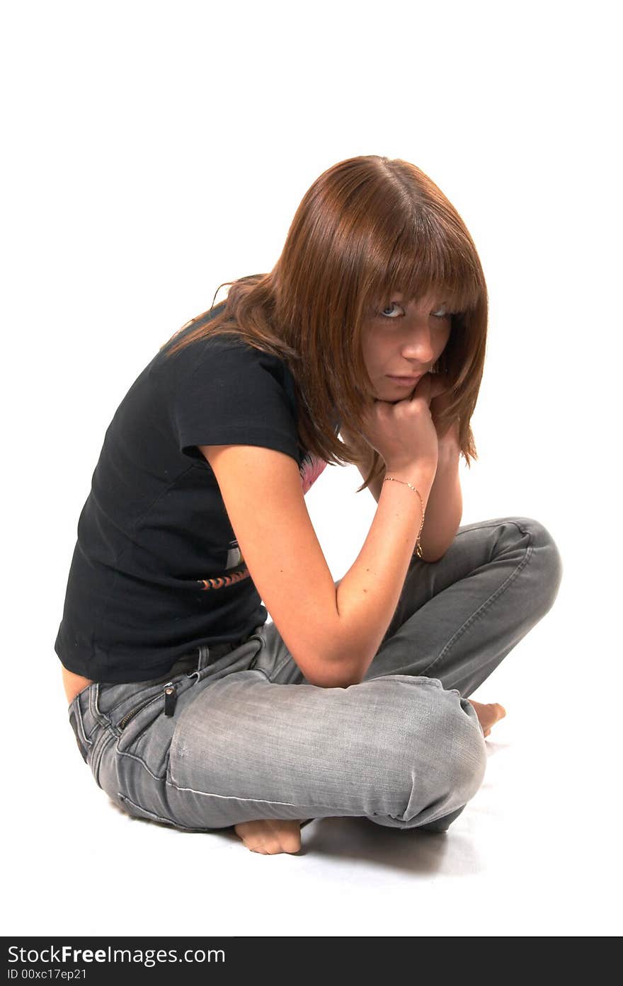 Girl in a black vest sits on a floor