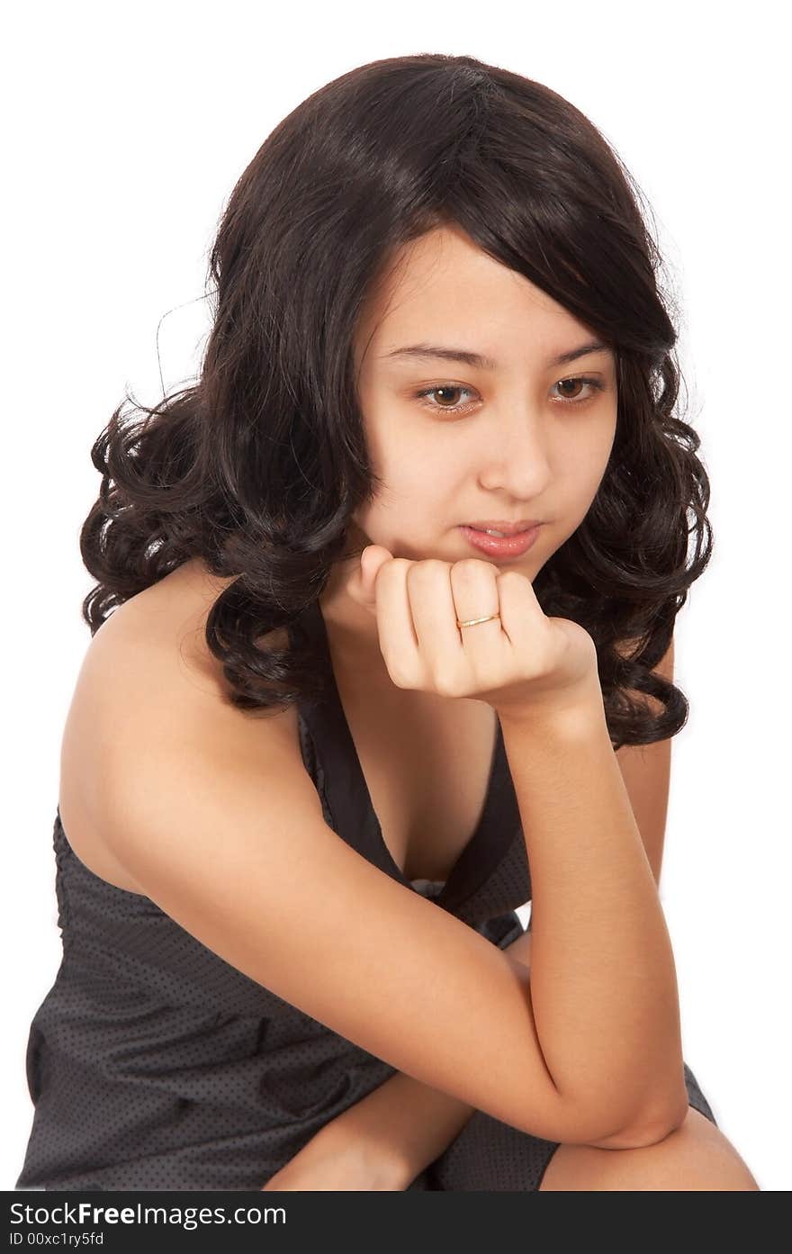 Attractive young girl with right hand on chin