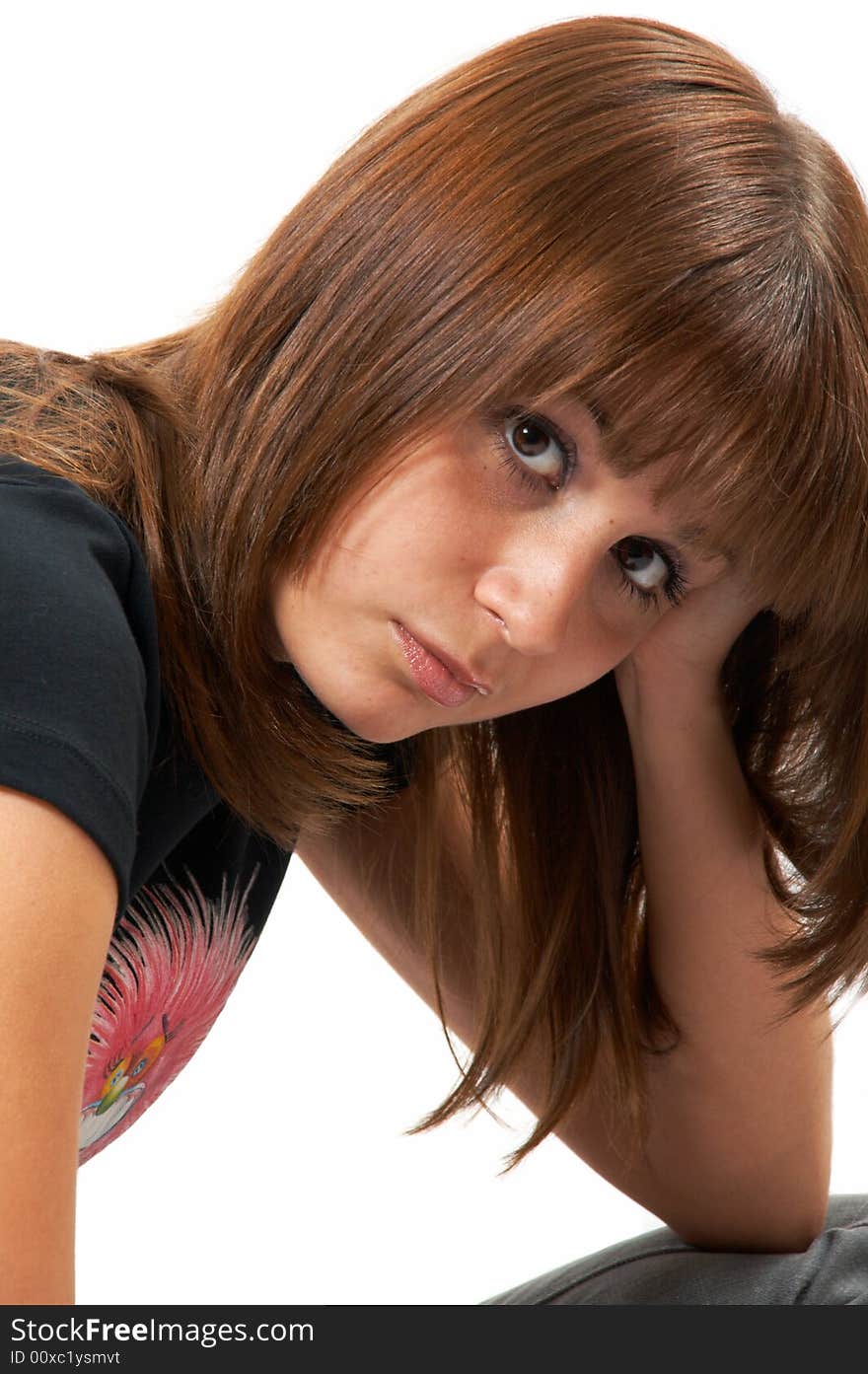 Girl in a black vest sits on a floor