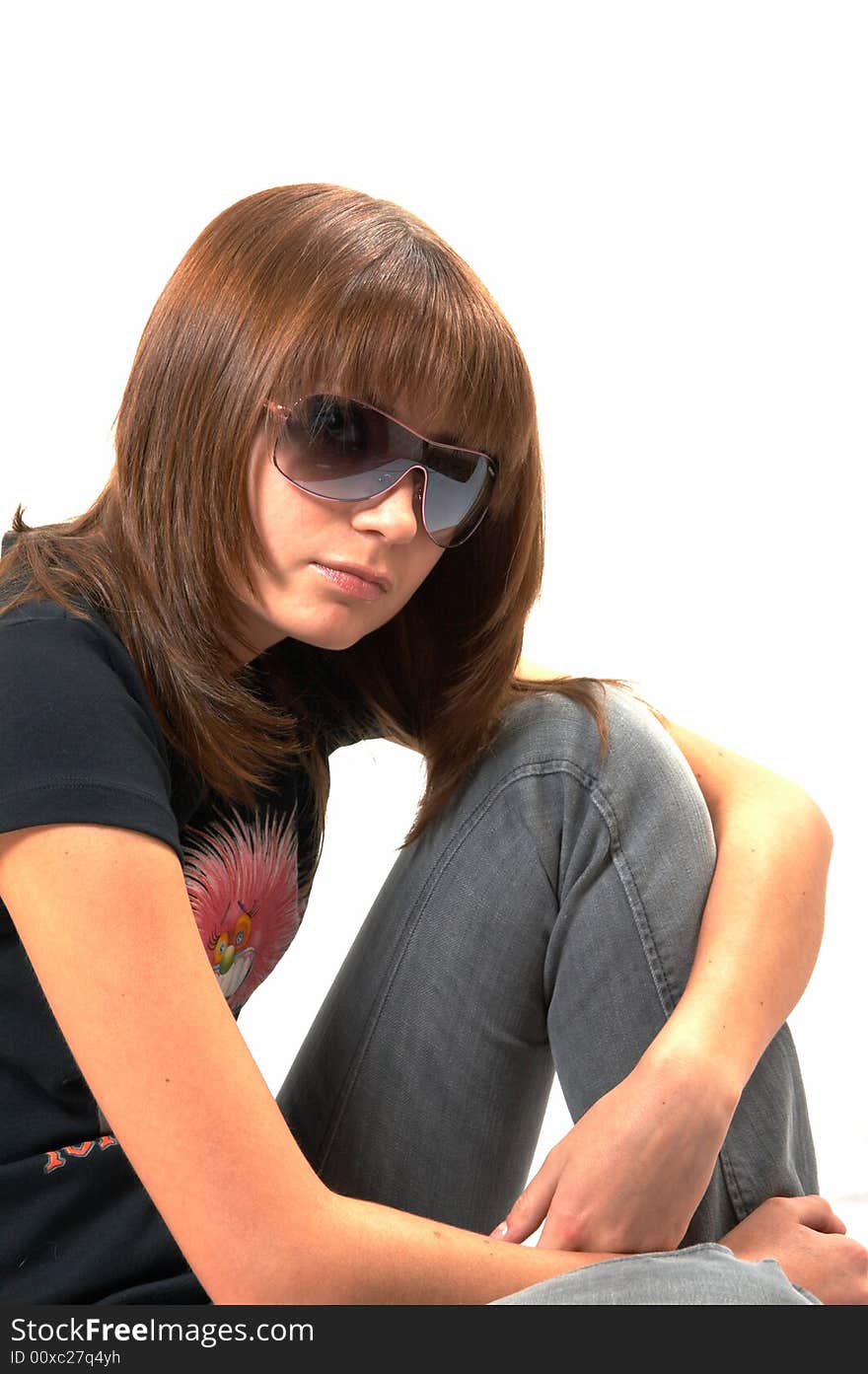 Girl in a black vest sits on a floor