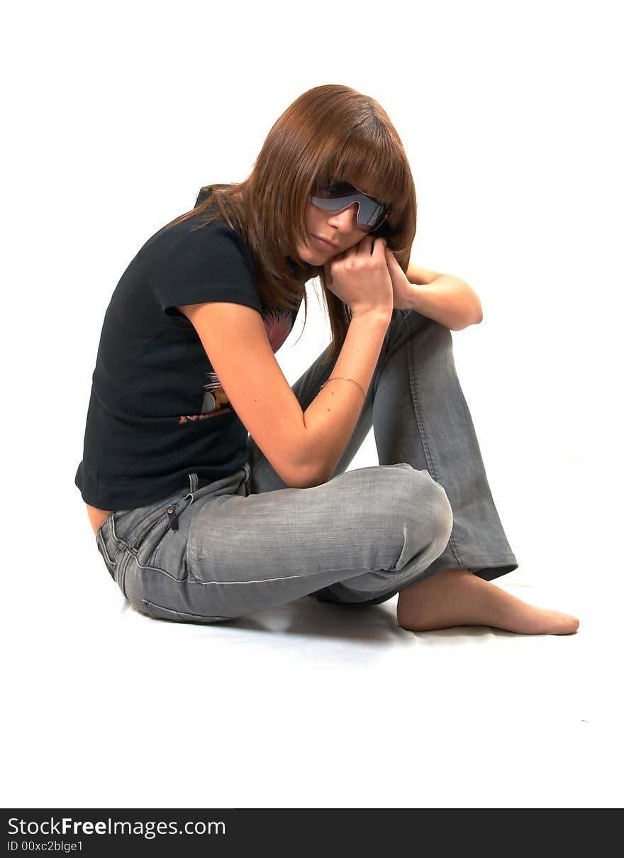 The girl in a black vest sits on a floor - a white background