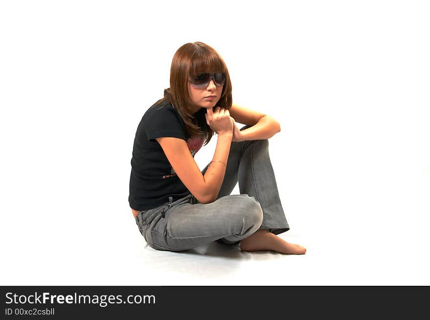 Girl in a black vest sits on a floor