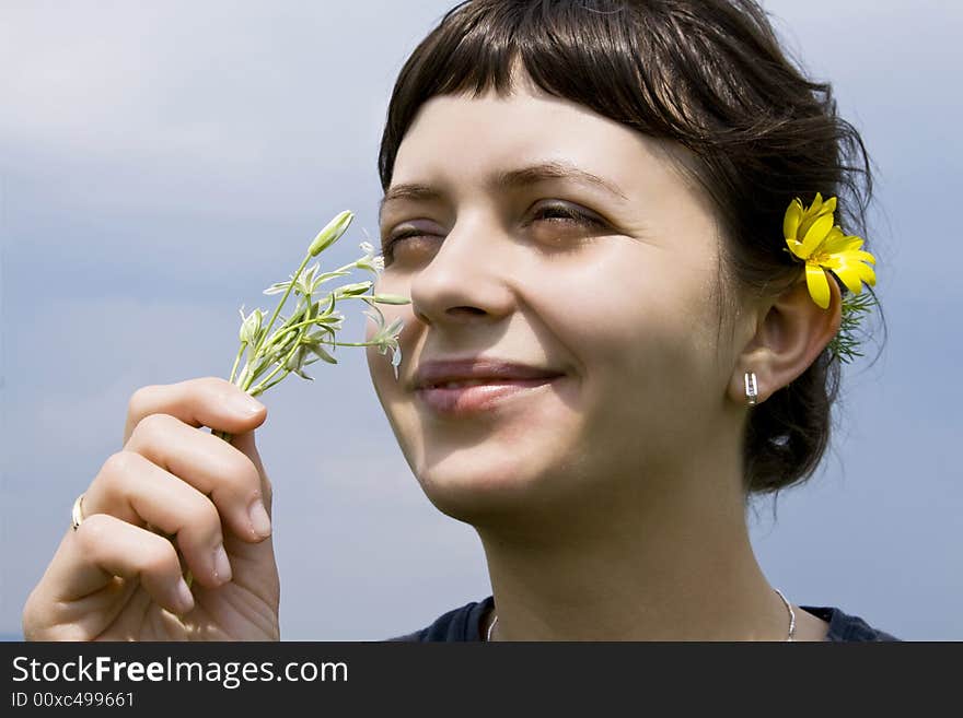 Young girl smelling wild flowers. Young girl smelling wild flowers