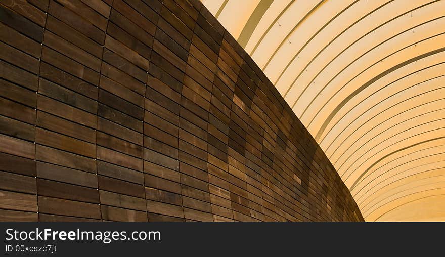 Abstract of metal arches and wood tiled wall in the morning light. Abstract of metal arches and wood tiled wall in the morning light