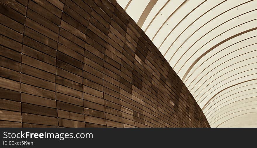 Abstract of metal arches and wooden tiled wall in the morning light. Abstract of metal arches and wooden tiled wall in the morning light