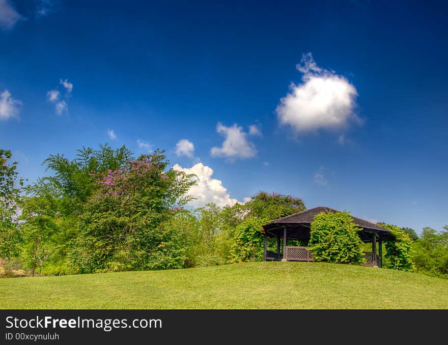 Solitary puff of cloud above a pavilion on a hill rise