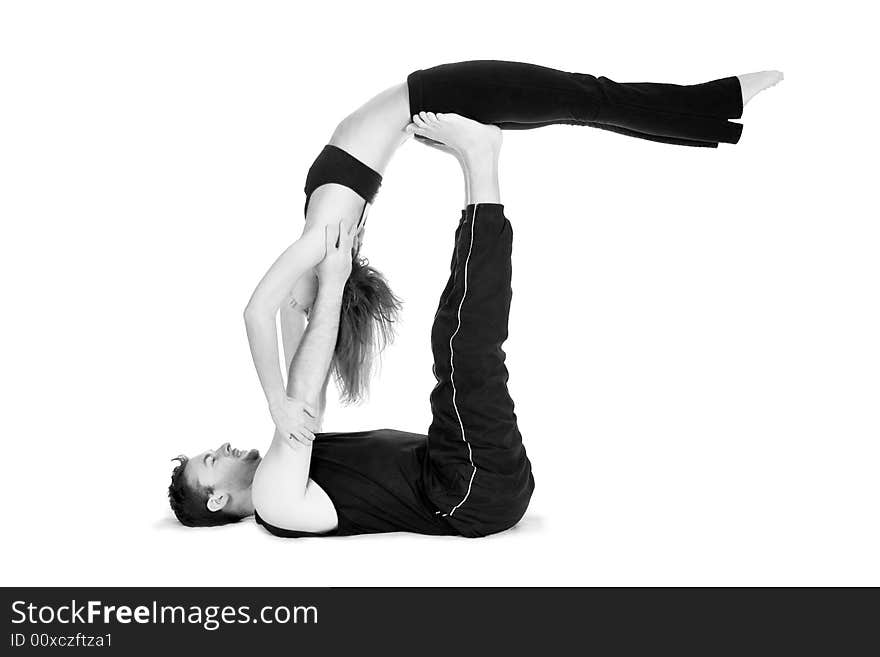 Male and female gymnasts practicing a complex double yoga pose. Male and female gymnasts practicing a complex double yoga pose.