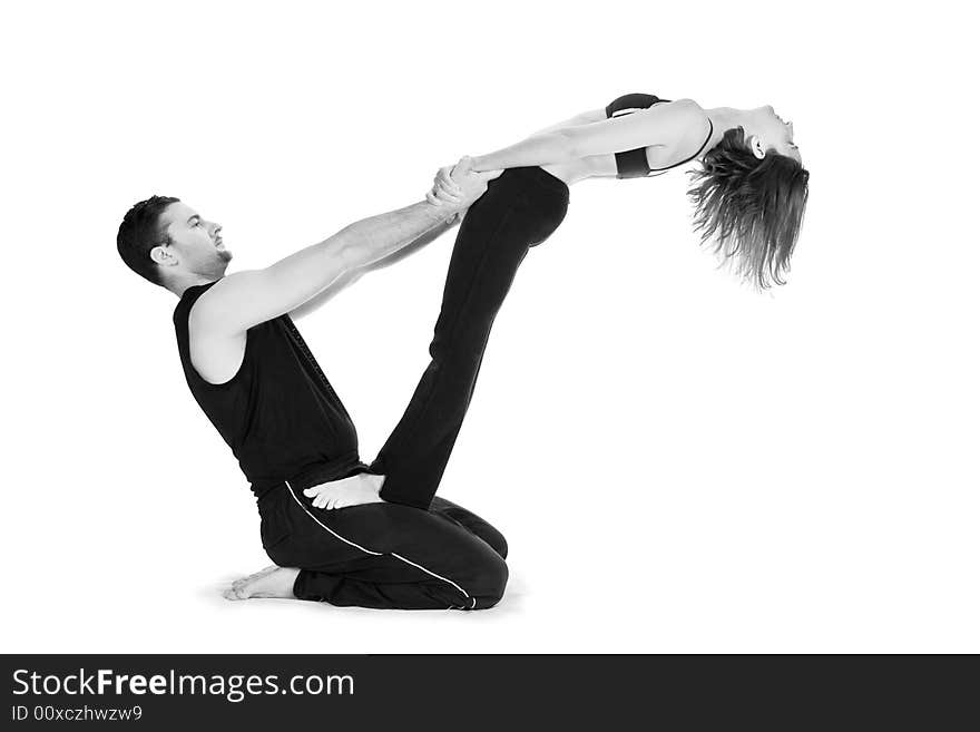 Male and female gymnasts practicing a complex double yoga pose. Male and female gymnasts practicing a complex double yoga pose.