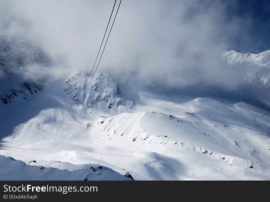 Steel ropes against snow glacier slope