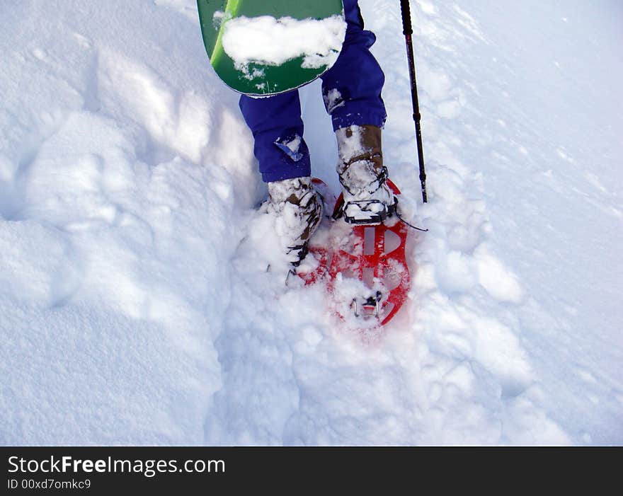 Man climb with a snowboard and snow shose. Man climb with a snowboard and snow shose