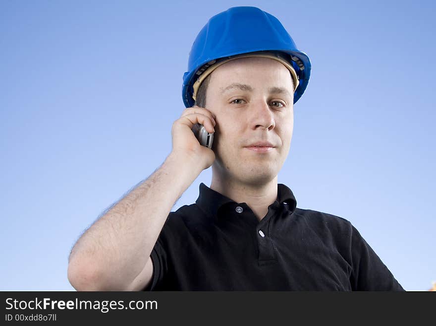 A young contractor takes a call on the job. Selective focus.