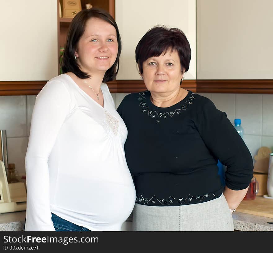 Portrait of mother and pregnant daughter taken in the kitchen