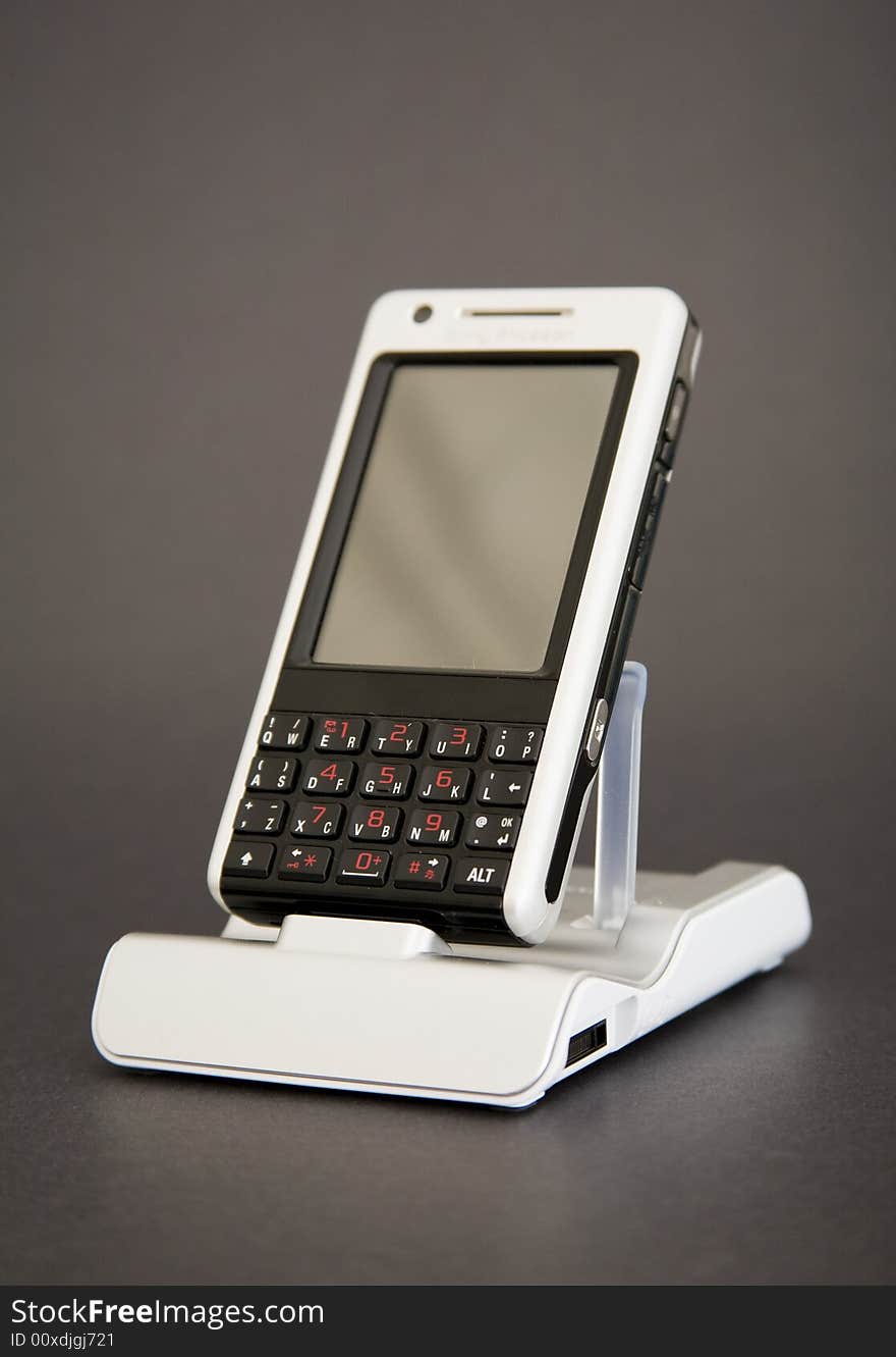 PDA phone in holder on dark background