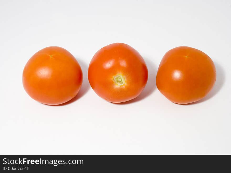 Tomatoes arranged in a raw set over the white background. Tomatoes arranged in a raw set over the white background