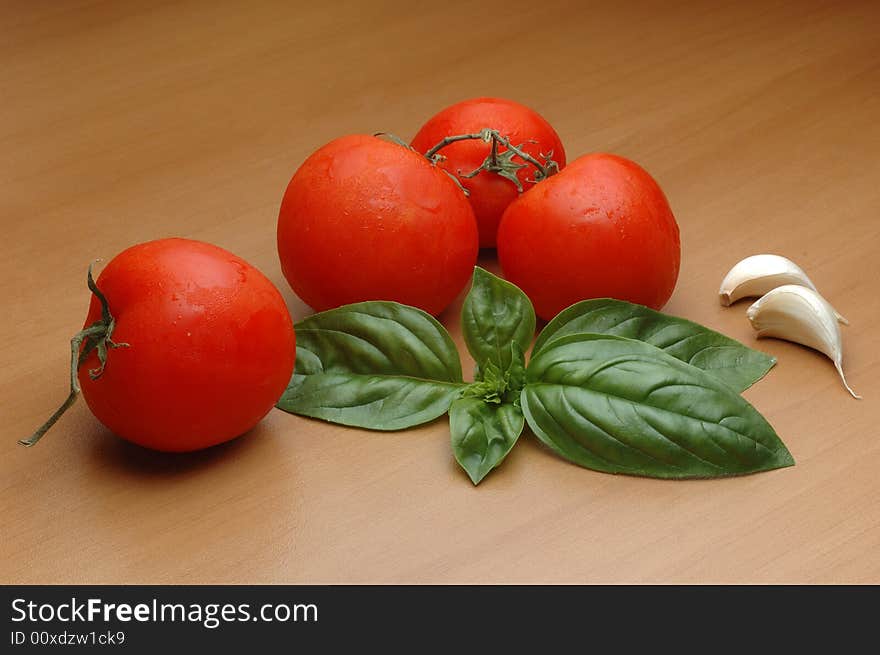 Tomatoes, basilico, and garlic over wooden background. Tomatoes, basilico, and garlic over wooden background