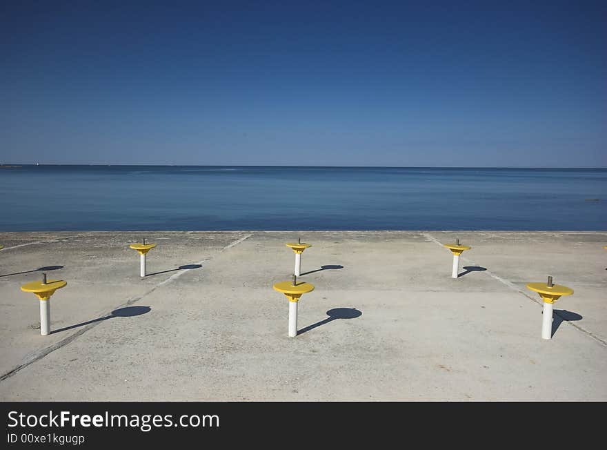 Umbrella holders on a terrace next to a sea