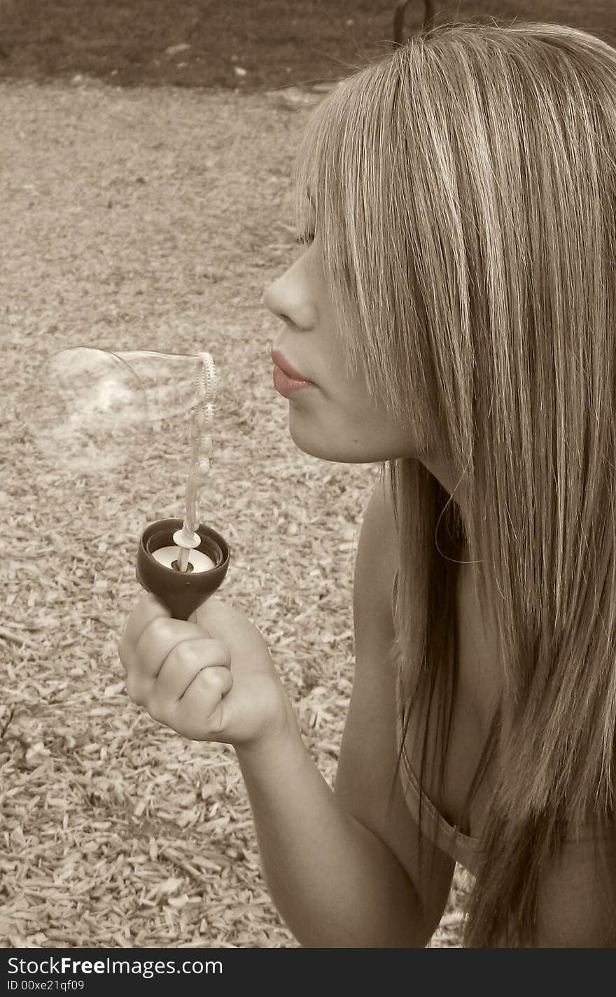 Closeup of a teenage girl blowing bubbles. Selective Colored Photo.